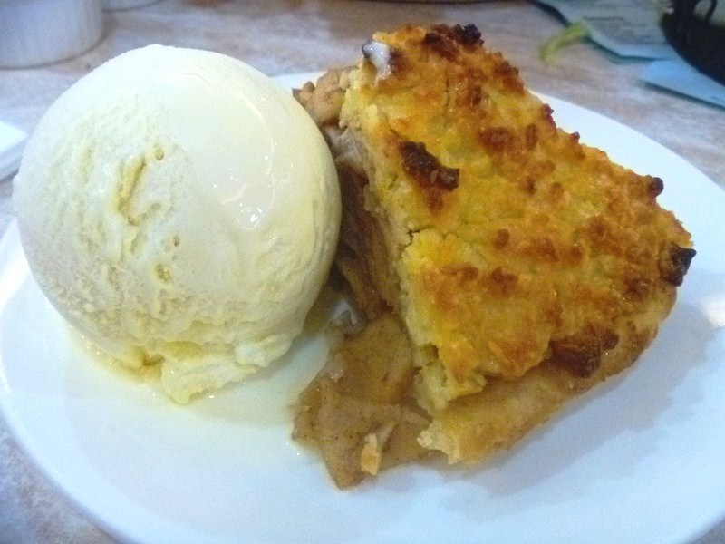 A slice of apple pie with a scoop of vanilla ice cream